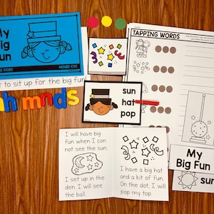 Puede incluir: Un conjunto de materiales educativos para jóvenes estudiantes, que incluye un libro colorido con el título "My Big Fun", letras magnéticas que deletrean "ah mnds" y varias hojas de trabajo con actividades como tocar palabras y trazar letras. Las hojas de trabajo incluyen ilustraciones de un sol, un sombrero y un pop.