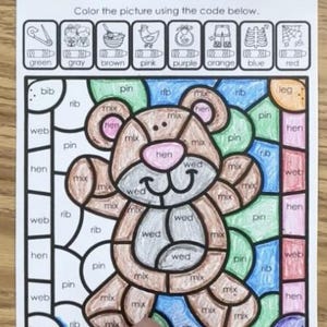 Op de afbeelding: Kleur-per-code-activiteitsblad met een teddybeer met een bruin lichaam, roze neus en blauwe ogen. Het blad is verdeeld in vierkanten met woorden zoals "rib", "web", "hen", "mix", "pin" en "wed" geschreven in elk vierkant. De woorden komen overeen met verschillende kleuren, die worden aangegeven in een legenda bovenaan het blad.