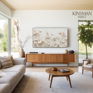 May include: A contemporary living room with a floral art print above a wooden media unit. A white sofa, round coffee table, and armchair are also present. The print is labelled "KINSMAN PRINT".