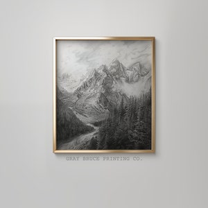 May include: A black and white drawing of a mountain range with a river flowing through the valley. The drawing is framed in a gold frame.