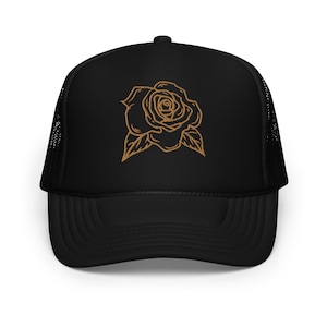May include: Black trucker hat with a gold outline of a rose on the front.