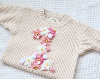 Cremefarbener Strickpullover für den ersten Geburtstag des Babys