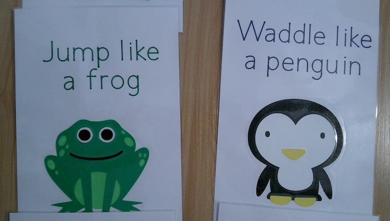 May include: Two educational cards with illustrations and text. One card says "Jump like a frog" with a green frog graphic. The other says "Waddle like a penguin" with a penguin graphic. The text and graphics are in black and green.