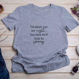 May include: Gray t-shirt with the text "I'd admit you are right... but then we'd both be wrong"