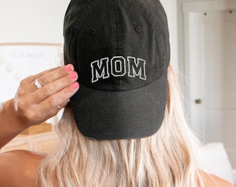 Puede incluir: Una gorra de béisbol negra con texto bordado en blanco que dice "MOM".