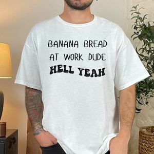 May include: White t-shirt with black text that reads "Banana Bread at Work Dude Hell Yeah".