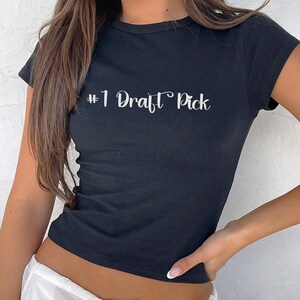 May include: Black cropped t-shirt with the text "#1 Draft Pick" in white.