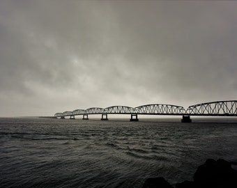 View of the Washington State-end of the Astoria-Megler Bridge over the Columbia River under stormy and overcast skies