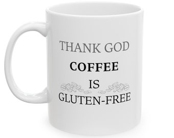Puede incluir: Taza de café de cerámica blanca con texto negro que dice "Thank God Coffee Is Gluten-Free". El texto está rodeado por un diseño de granos de café.