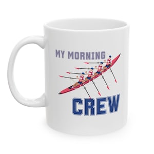 Puede incluir: Taza de cerámica blanca con un gráfico de un equipo de remo en rojo y azul y el texto "MY MORNING CREW".
