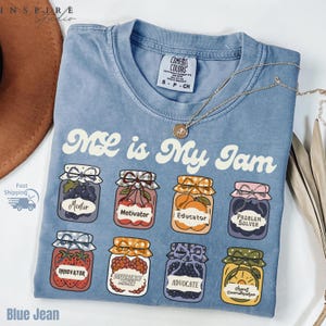 May include: Blue jean t-shirt with the text "ML is My Jam" and illustrations of jam jars labeled "Mentor", "Motivator", "Educator", "Problem Solver", "Innovator", "Difference Maker", "Advocate", and "Chaos Coordinator".