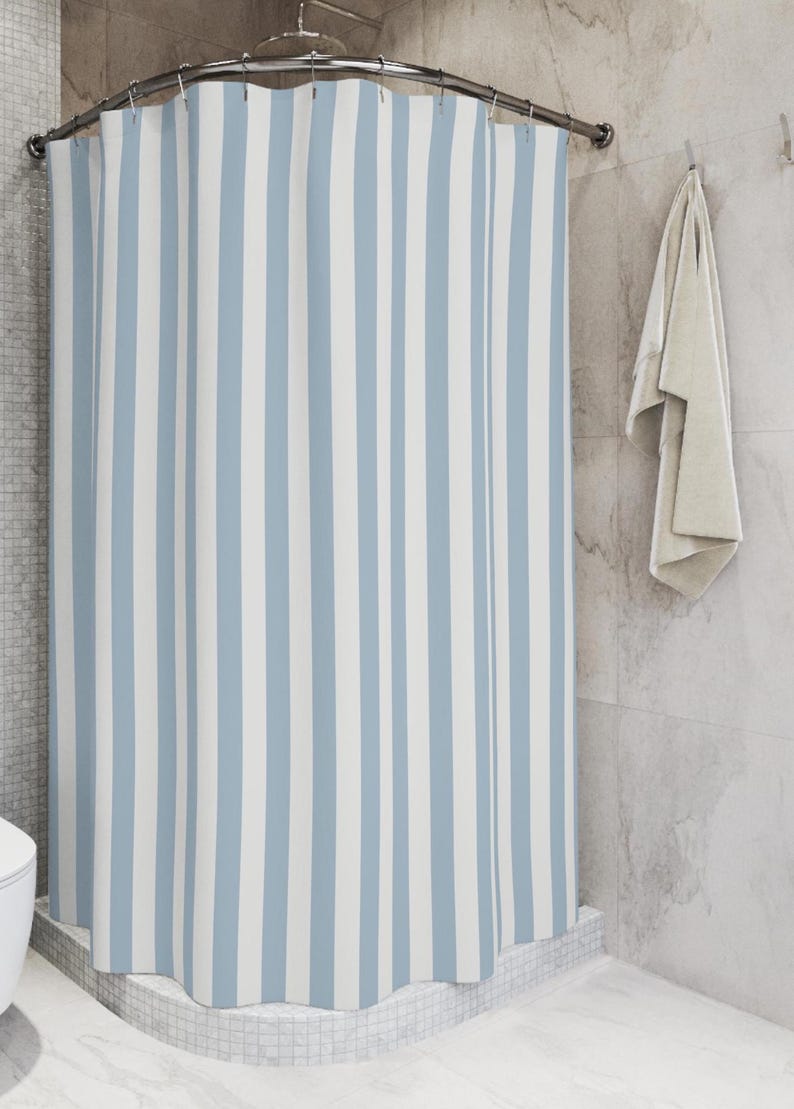 A light blue and white striped shower curtain; minimalist, modern, beachy aesthetic.