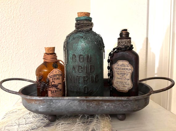 A handcrafted gothic apothecary set with faux-rusted tray and potion bottles that looks like it was pulled straight from a Victorian witch's cabinet.