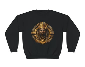 May include: Black sweatshirt featuring a gold-colored graphic of a crowned person with the text "AKIN KING" in a circular design. The graphic has intricate details and a regal aesthetic. The sweatshirt is made of a soft material.