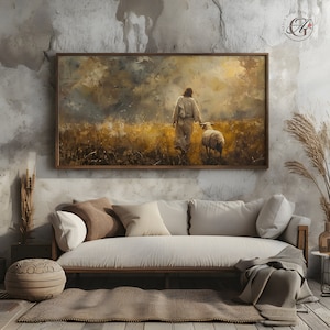 May include: A painting of a man in a white robe walking through a field with a sheep. The sky is cloudy and the field is green and brown. The painting is framed in a brown wood frame.