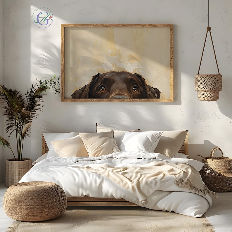 Puede incluir: La cabeza de un perro marr&oacute;n y blanco asoma por encima de un marco de imagen de madera. Los ojos del perro son visibles y la imagen est&aacute; colgada en una pared blanca sobre una cama con ropa de cama blanca y una manta de lana marr&oacute;n.