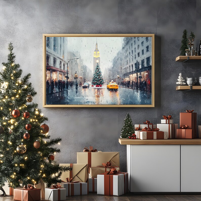 May include: A framed painting of a snowy city street scene with a Christmas tree in the center. The street is lined with buildings and there are cars driving by. The painting is in a gold frame and is hanging on a gray wall.