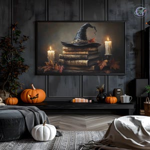 Puede incluir: Un sombrero de bruja negro se sienta encima de una pila de libros antiguos encuadernados en cuero. Dos velas encendidas y hojas de otoño están dispuestas alrededor de los libros. La imagen está sobre un fondo oscuro y misterioso.