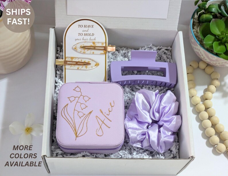 May include: A gift box containing a light purple hair claw clip, scrunchie, and jewelry box with the name "Alice" and floral design. Includes two gold-toned hair clips and the text "TO HAVE and TO HOLD your hair back".