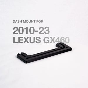 Puede incluir: Un soporte de salpicadero negro para vehículos Lexus GX460 de 2010-23. El soporte es rectangular con una serie de agujeros y esquinas anguladas. El texto "DASH MOUNT FOR 2010-23 LEXUS GX460" está impreso encima del soporte.