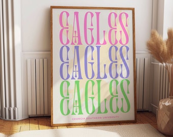 May include: A framed print with the word "EAGLES" repeated three times in different colors: pink, purple, and green. The text is on a cream background. The bottom of the print reads "GEORGIA SOUTHERN UNIVERSITY".