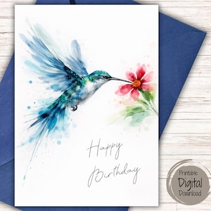May include: A greeting card featuring a watercolor illustration of a blue and green hummingbird hovering near a pink flower. The text Happy Birthday is printed in black script on the white background of the card, which rests on a blue envelope.