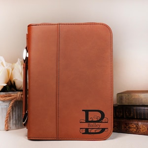 May include: A brown leather zippered bible cover with a personalized monogram and the name "Bailey" engraved on the front.