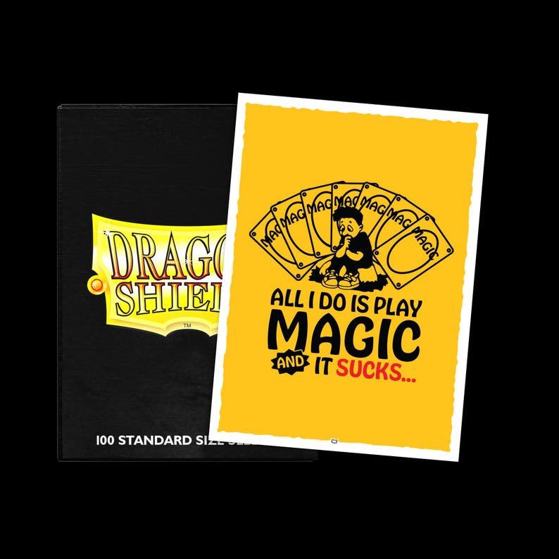 Puede incluir: Una caja negra para guardar cartas con el texto "DRAGON SHIELD" en amarillo y blanco. Junto a ella, una tarjeta amarilla con una imagen de dibujos animados y el texto "ALL I DO IS PLAY MAGIC AND IT SUCKS..."