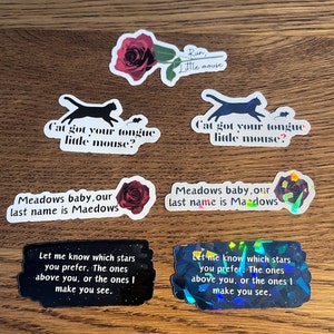 May include: A set of nine stickers featuring various designs, including a black cat, a red rose, and a black and white illustration of a mouse. The stickers have text that reads "Run, Little Mouse", "Cat got your tongue little mouse?", and "Meadows baby, our last name is Maedows".