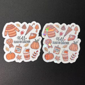 May include: Two sets of fall-themed stickers with a variety of images, including a sweater, pumpkin spice latte, pumpkin, leaves, and an umbrella. The text on the stickers reads "Hello Sweater Weather".