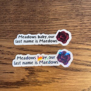May include: Two stickers with a red rose and the text "Meadows baby, our last name is Maedows".