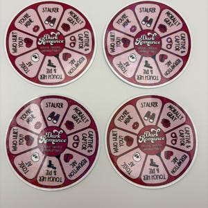 May include: Four circular stickers with a pink and white design. Each sticker features a central graphic with the words "Dark Romance" and surrounding text like "Stalker" and "You're Mine".