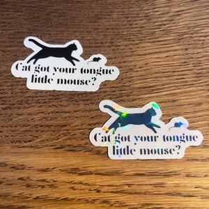 May include: Two stickers with a black silhouette of a cat chasing a mouse. The text on the stickers reads "Cat got your tongue little mouse?"