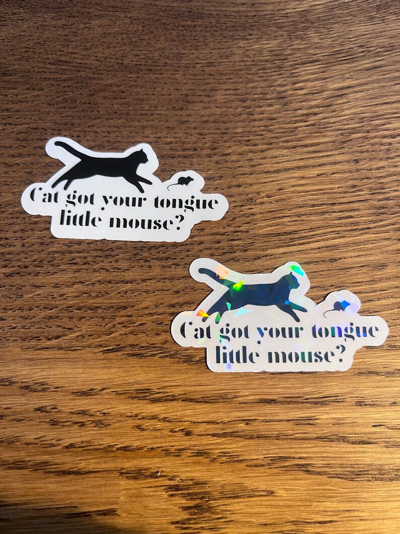 May include: Two stickers with a black silhouette of a cat chasing a mouse. The text on the stickers reads "Cat got your tongue little mouse?"