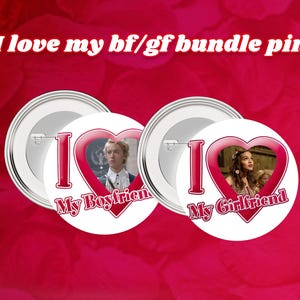 Puede incluir: Dos pines de botón blancos con corazones rojos. El corazón del pin izquierdo tiene una foto de un hombre y el texto "I Love My Boyfriend". El corazón del pin derecho tiene una foto de una mujer y el texto "I Love My Girlfriend".