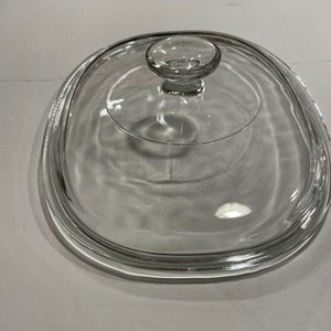 May include: Clear glass lid for a slow cooker with a round knob on top.