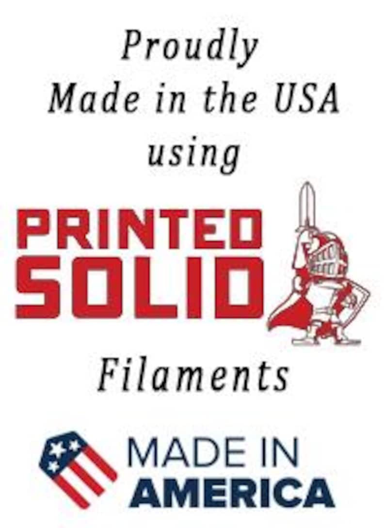 K&ouml;nnte beinhalten: Ein rot-wei&szlig;es Logo mit dem Text "PRINTED SOLID" und den Worten "Proudly Made in the USA using Filaments MADE IN AMERICA" darunter.