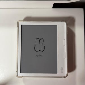 May include: A white Kobo e-reader with a gray screen displaying a simple illustration of a bunny with the text "my kobo".
