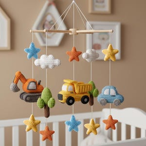 Puede incluir: Móvil para bebé hecho a mano con vehículos y formas celestiales de ganchillo. El móvil incluye una excavadora naranja, un camión volquete amarillo y un coche azul, junto con estrellas y nubes de varios colores. Suspendido de un marco de madera.