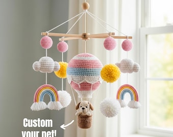 May include: A handmade baby mobile featuring a hot air balloon with pink, blue, and white stripes, a dog in a basket, rainbows, clouds, and pom-poms. The text "Custom your pet!" is also included.
