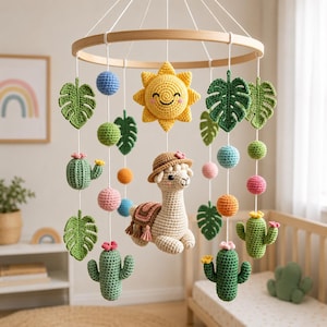 May include: A crochet mobile featuring a central beige llama wearing a hat, surrounded by yellow suns, green monstera leaves, cacti with pink and yellow flowers, and multicolored spheres hanging from a circular wooden frame with white strings.