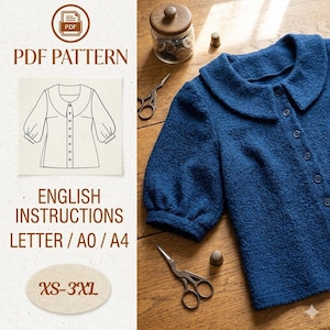 May include: A blue textured blouse with a rounded collar and button-up front. The image includes a PDF pattern graphic, English instructions, and size range XS-3XL. Sewing scissors and a thimble are also visible.
