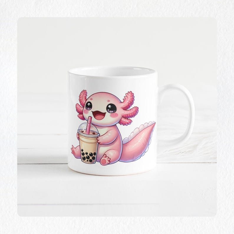 May include: White ceramic mug featuring a cartoon axolotl holding a boba tea. The axolotl is pink with large eyes and a smiling expression. The boba tea is in a clear cup with a pink straw. The mug has a white handle.
