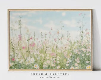 May include: A rectangular wall art print in a thin gold frame featuring a watercolor painting of a wildflower meadow with white and pink blossoms against a soft blue sky. The text BRUSH & PALETTES art collective is printed below the image.