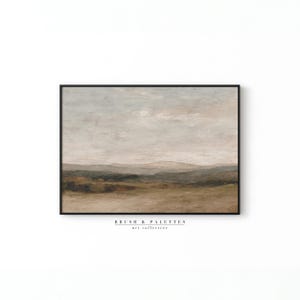 May include: An abstract landscape painting in a black frame. The artwork features a muted color palette of beige, brown, and green, depicting rolling hills under a cloudy sky. The text "BRUSH & PALETTES art collective" is at the bottom.