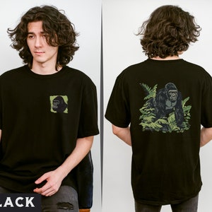 May include: Black t-shirt with a gorilla graphic on the back and a smaller gorilla graphic on the front. The gorilla graphic on the back shows the gorilla walking through a jungle scene.