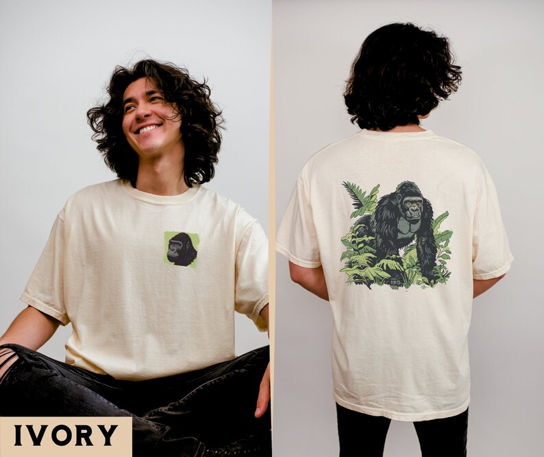 May include: A cream colored t-shirt with a black and green gorilla graphic on the back and a smaller version of the graphic on the front. The text "IVORY" is printed in black at the bottom of the image.