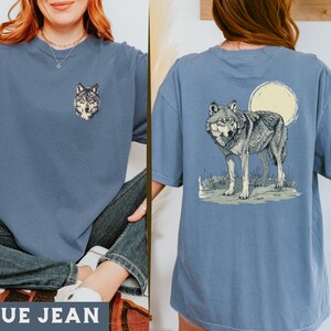 May include: A blue jean t-shirt with a wolf graphic on the front and a wolf howling at the moon graphic on the back.