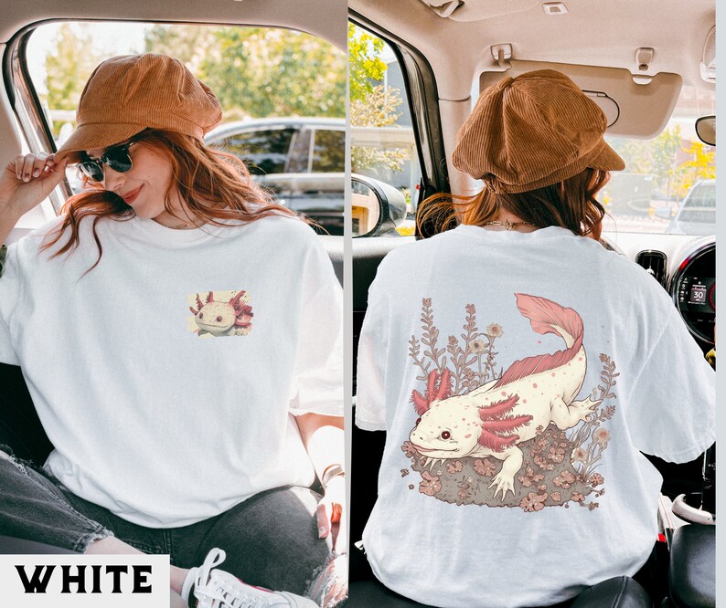 May include: White t-shirt with a pink and white axolotl illustration on the front and a larger pink and white axolotl illustration on the back. The axolotl is surrounded by small pink flowers.