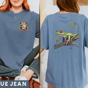 May include: A blue jean t-shirt with a green tree frog graphic on the front and a green tree frog on a branch graphic on the back.